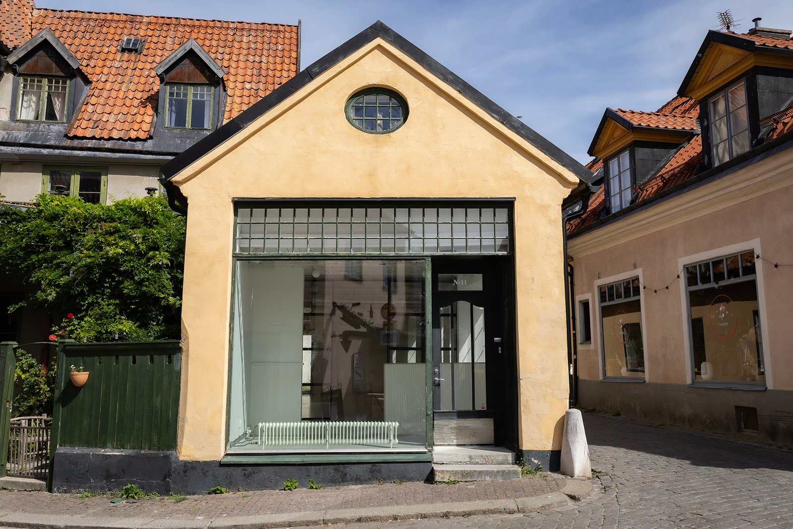 Husets gula fasad med stort skyltfönster